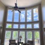 Living room with high ceiling and large floor-to-ceiling vinyl windows